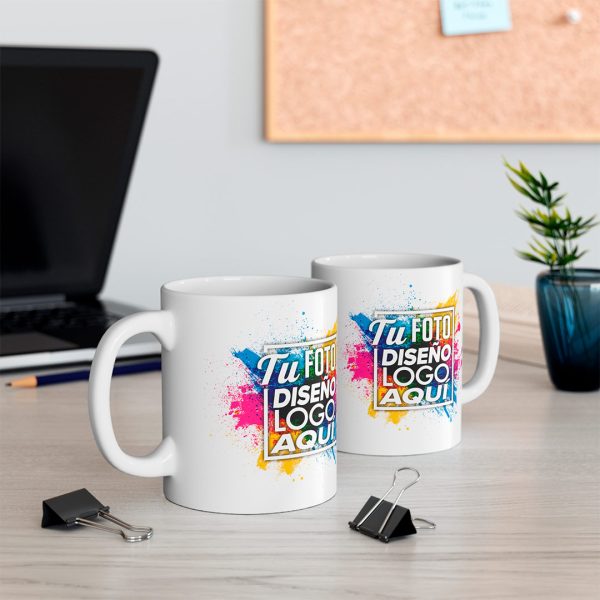 Dos tazas personalizadas 11 oz con diseño corporativo sobre un escritorio de trabajo
